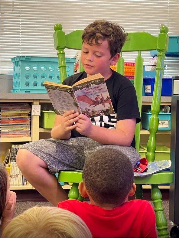 student reading to class